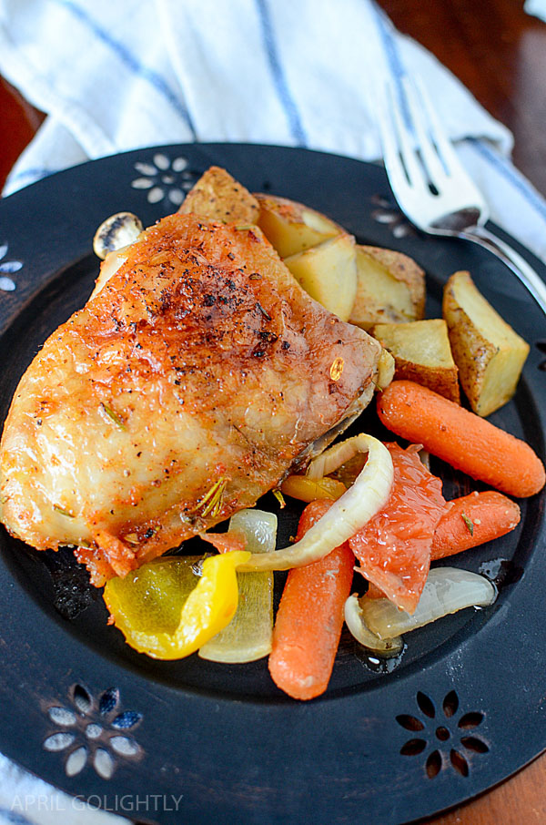 Citrus baked chicken on a plate with carrots and potatoes