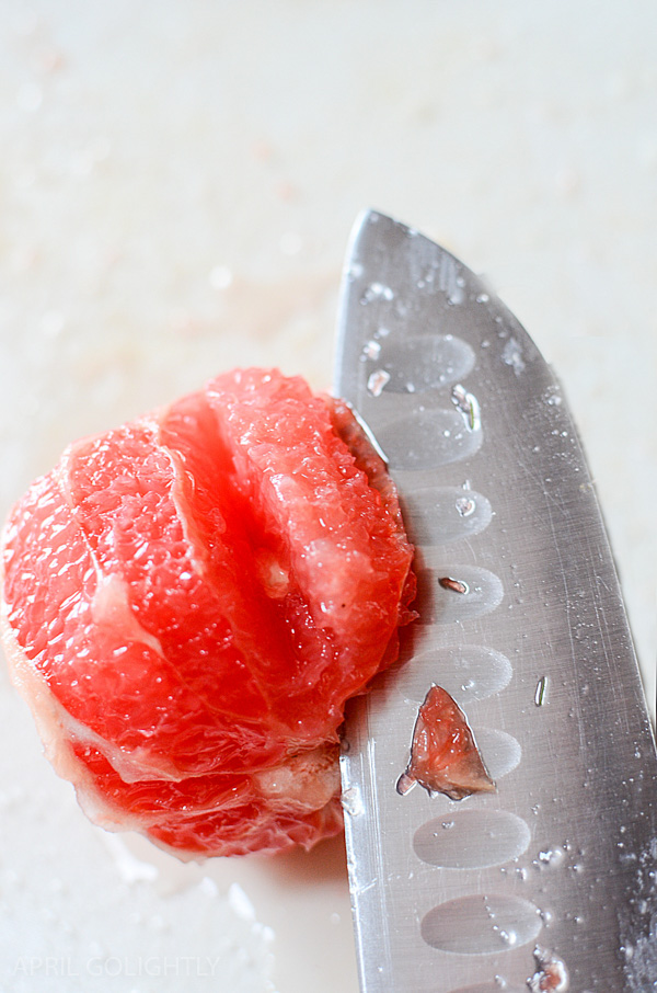 A knife cutting a grapefruit